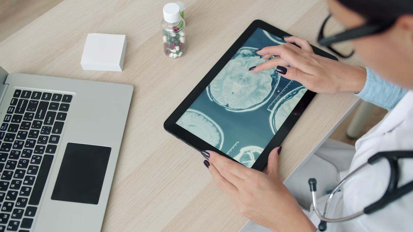 Physician reviewing diagnostic imaging on a tablet at a clinical desk